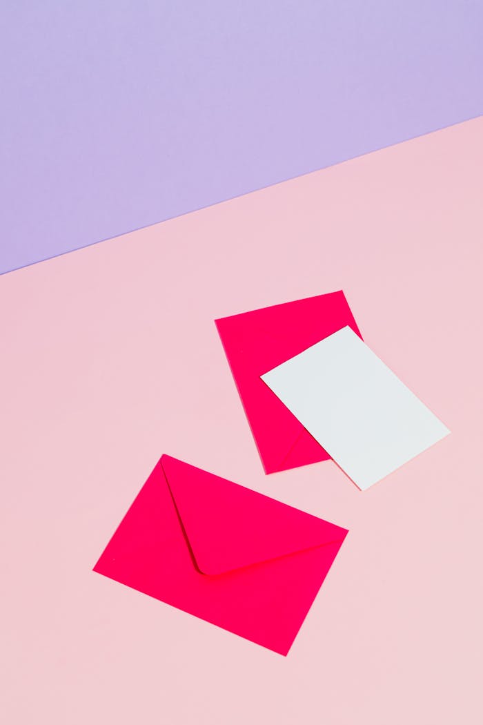 Bright pink envelopes and card on pastel background. Ideal for stationery themes.